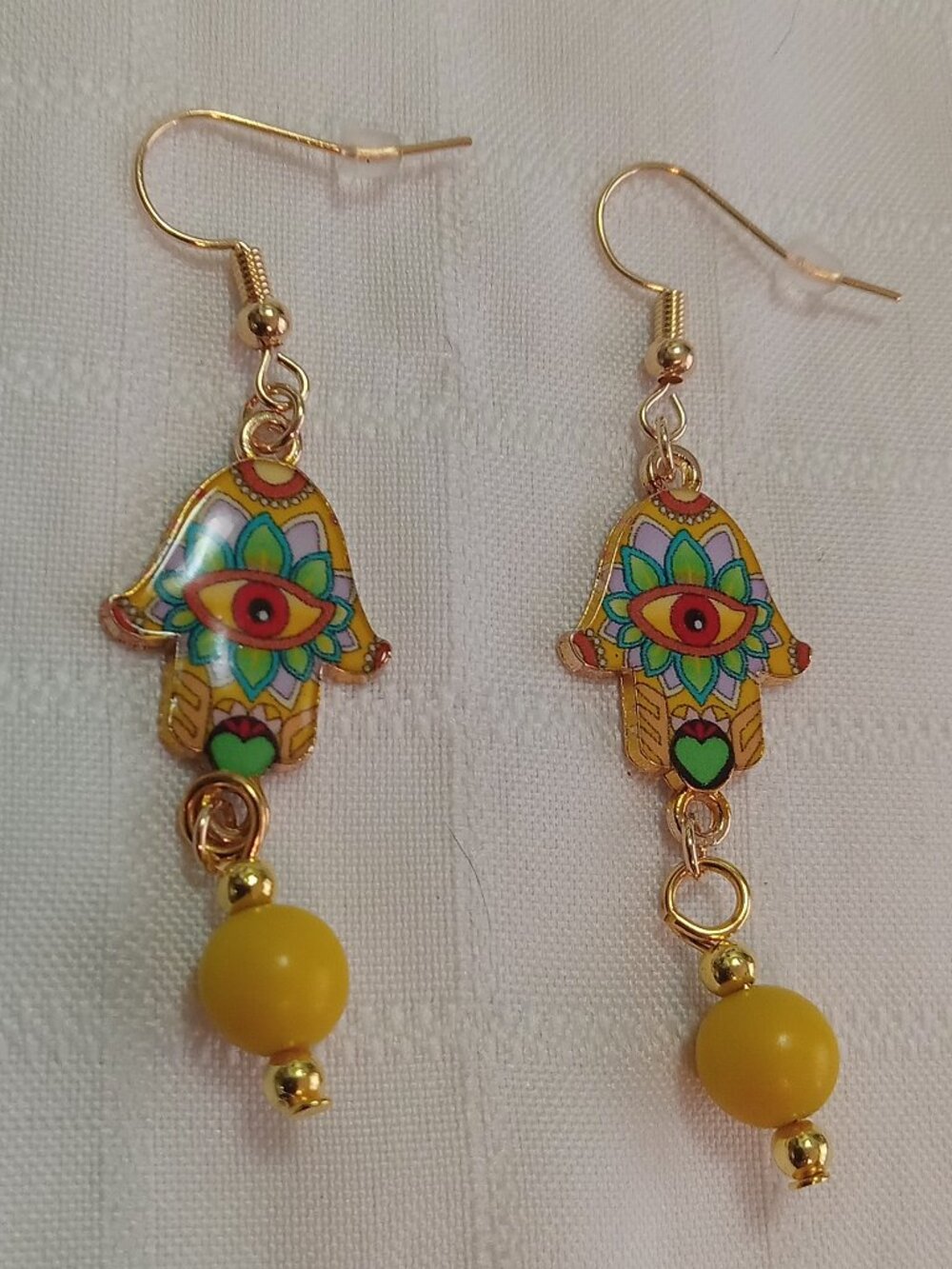 Handmade gold-colored earrings with multicolored enameled fatima hands and beads